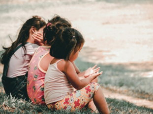 three children sitting on grass
